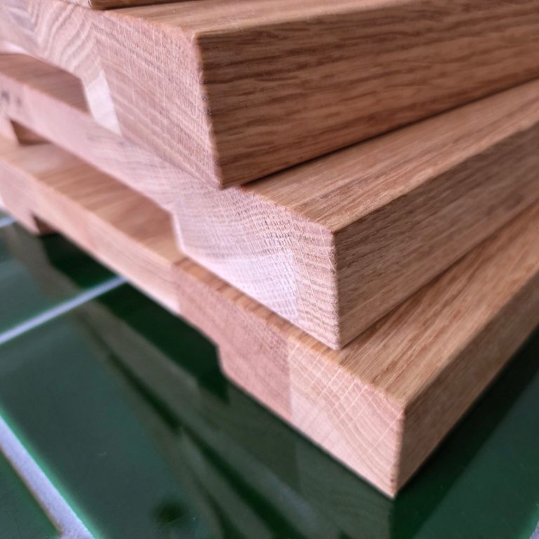 Ljust trä med tydlig ådring i en vinkel av en möbel. Barnstol med Namn